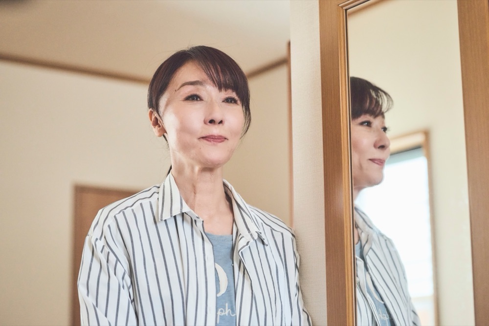 茂木陽子を演じる浅野ゆう子。鏡の前で静かに佇む。