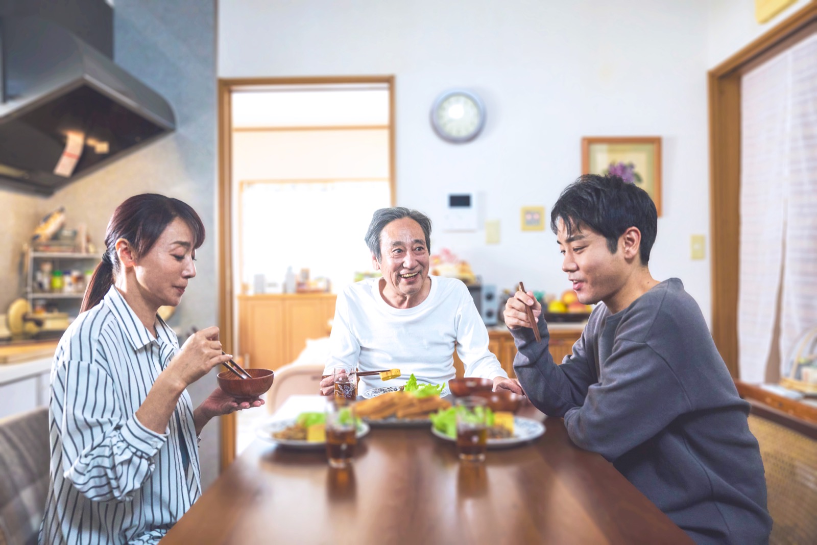 食卓を囲んで笑い合う家族。